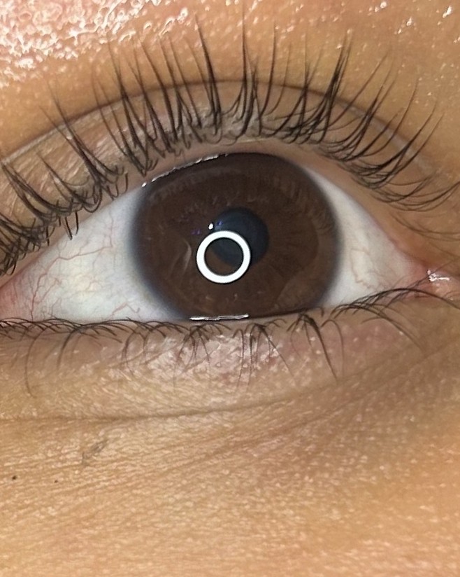 Gelifte wimpers boven een bruin oog