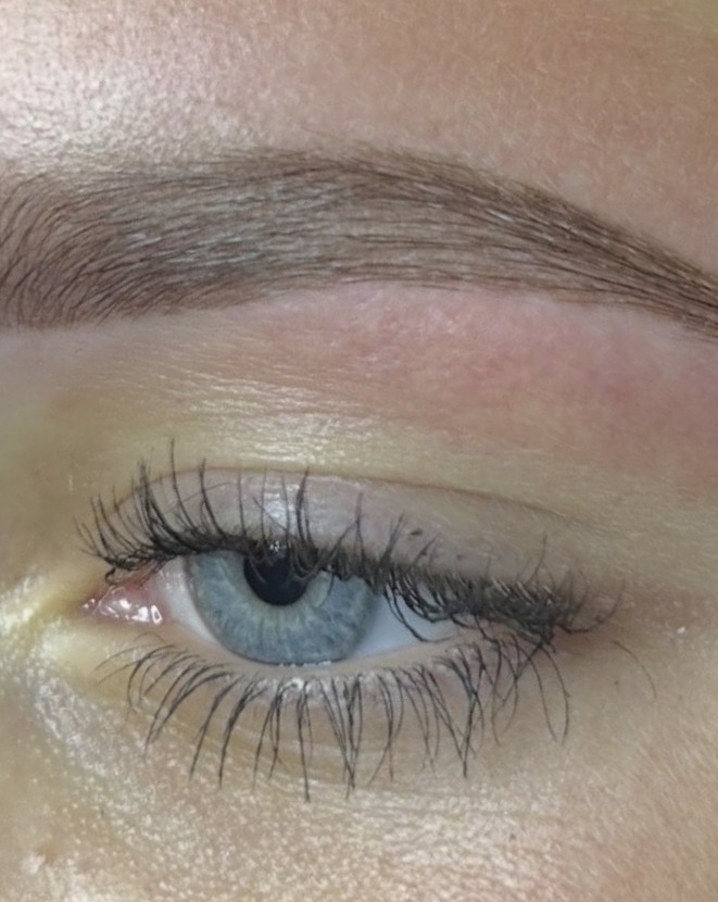 Volle, gevormde wenkbrauw boven een blauw oog